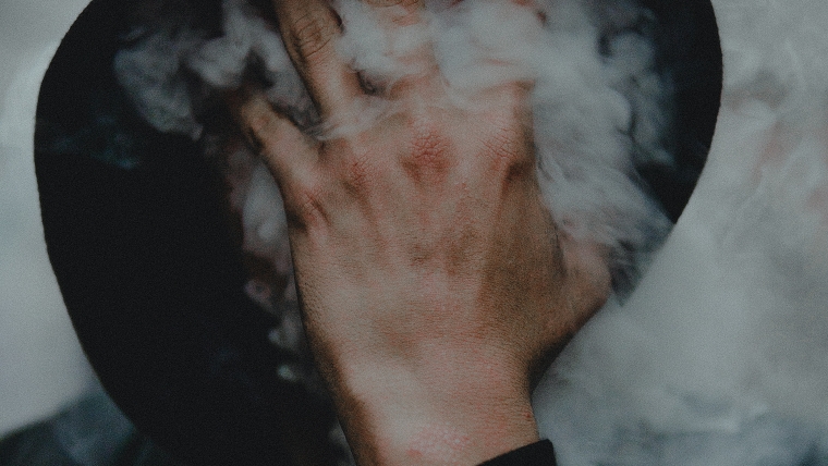 fumer cigarette au visage caché par la main